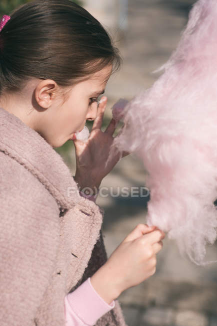 Chica comiendo algodón de azúcar - foto de stock