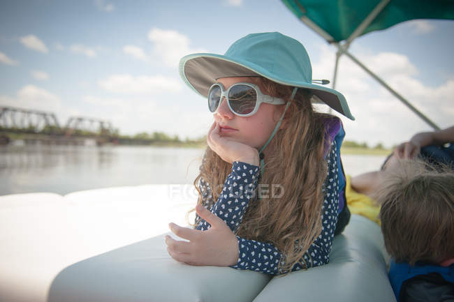 Ragazza sdraiata sulla barca in ombra — Foto stock