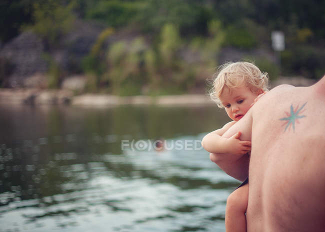 Padre che porta suo figlio al lago — Foto stock