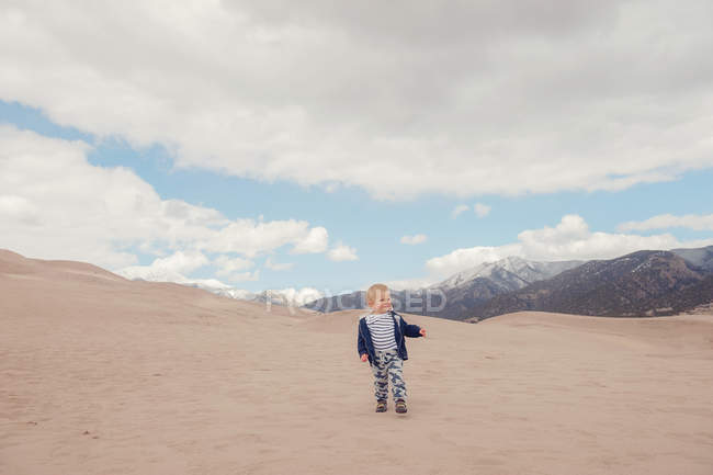 Garçon courant dans un grand parc national de dunes de sable — Photo de stock