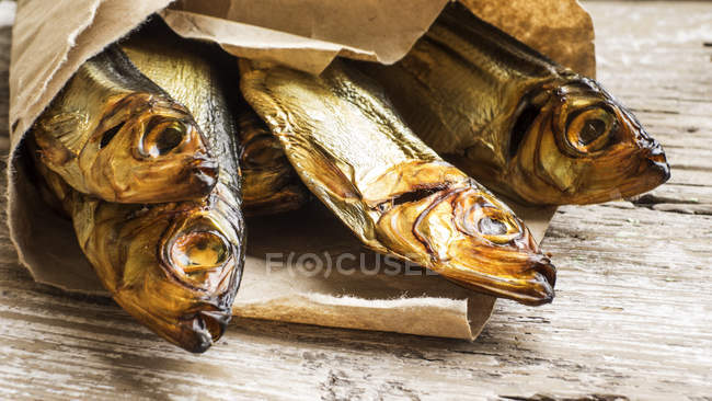 Smoked herring in paper bags — Stock Photo