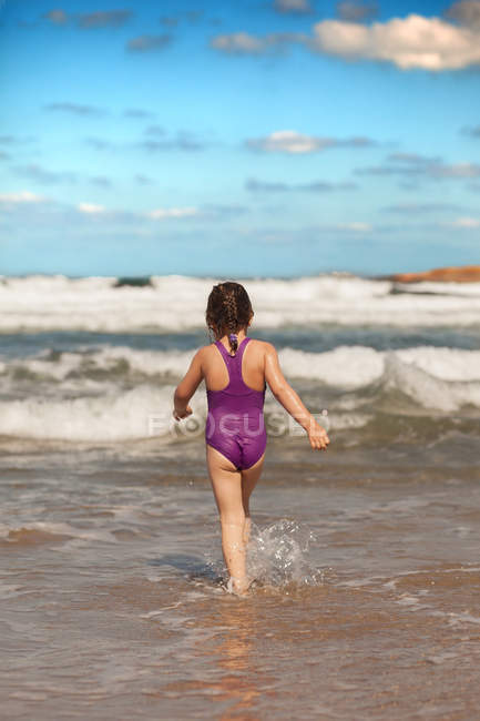 Chica caminando en el mar - foto de stock