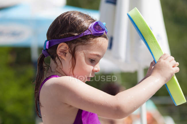 Girl standing by swimming pool — Stock Photo