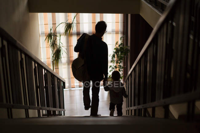 Padre e hijo bajando escaleras - foto de stock
