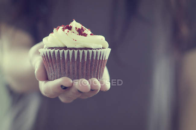 Menina segurando veludo cupcake — Fotografia de Stock