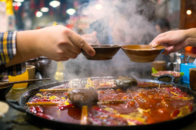 Personas comiendo hotpot chino - foto de stock