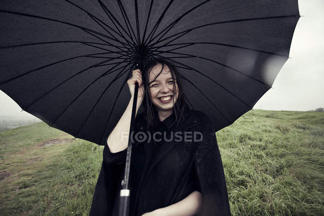 Mulher segurando guarda-chuva no vento — Fotografia de Stock