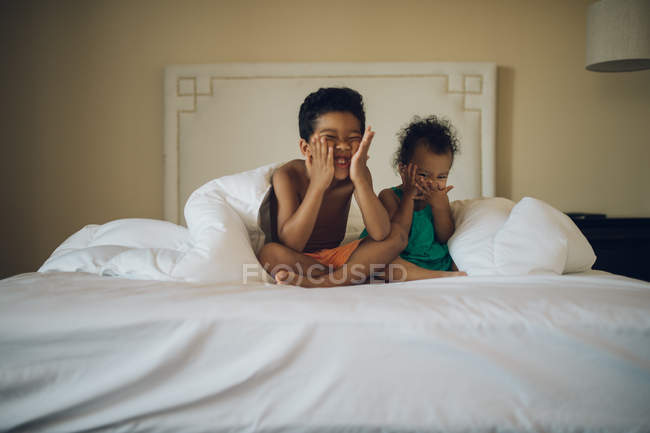 Little kids having fun on bed — Stock Photo