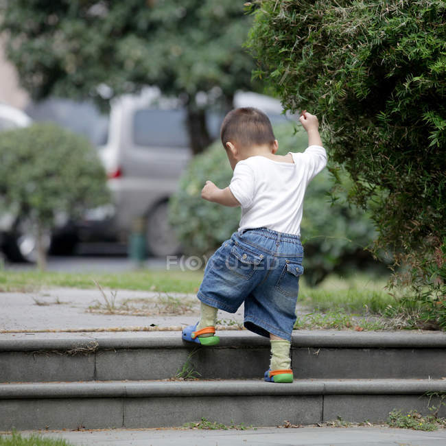 Pequeno menino andando em cima de escadas — Fotografia de Stock