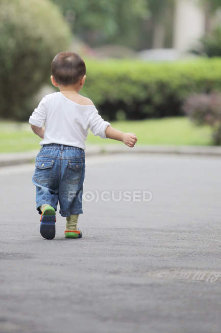 Petit garçon marchant dehors — Photo de stock