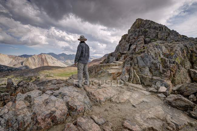 Чоловік стоїть на горах під небом — стокове фото