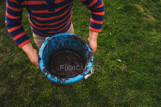 Man holding muddy bucket — Stock Photo