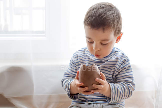 Хлопчик їсть шоколадне великоднє яйце — стокове фото