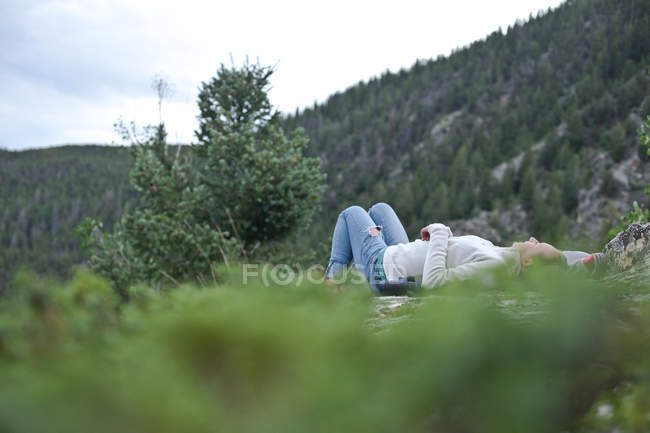 Menina deitada em rochas — Fotografia de Stock