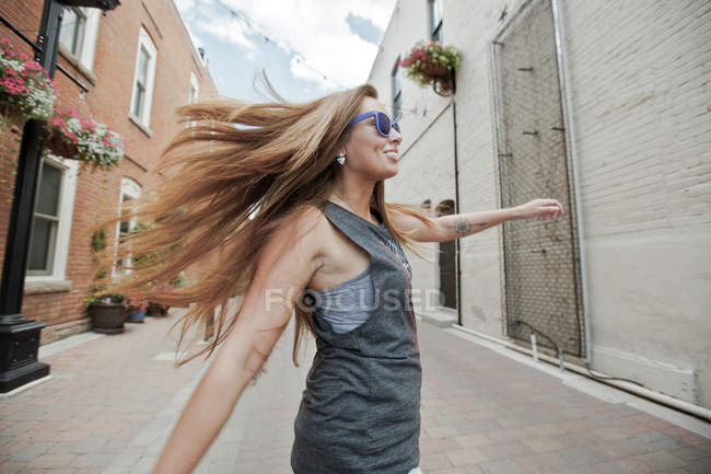 Woman spinning in city street — Stock Photo
