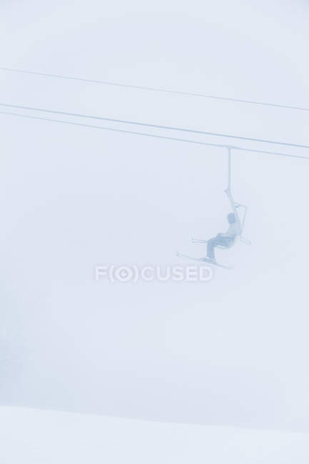 Лыжник, сидящий на подъемнике — стоковое фото