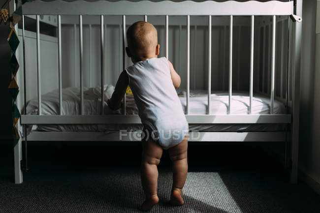 Хлопчик стоїть на ліжку в спальні — стокове фото