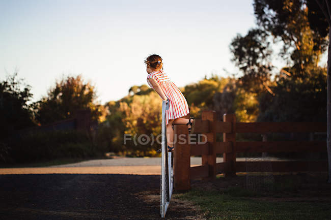 Mädchen klettert auf Tor — Stockfoto