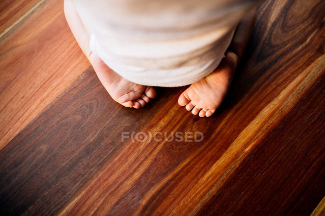 Menino ajoelhado com close-up de pés — Fotografia de Stock