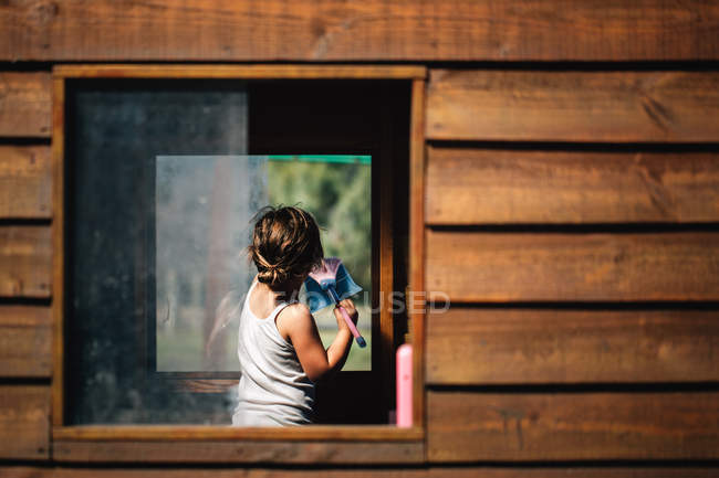 Девушка моет окна — стоковое фото