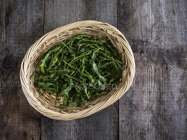 Basket of arugula salad leaves — Stock Photo