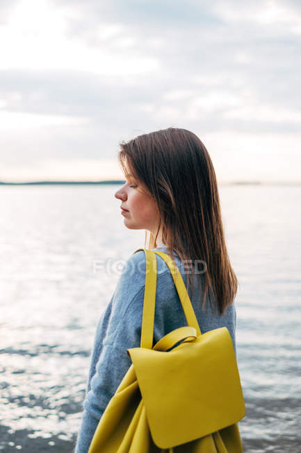 Mulher de pé junto ao mar e olhando para longe — Fotografia de Stock