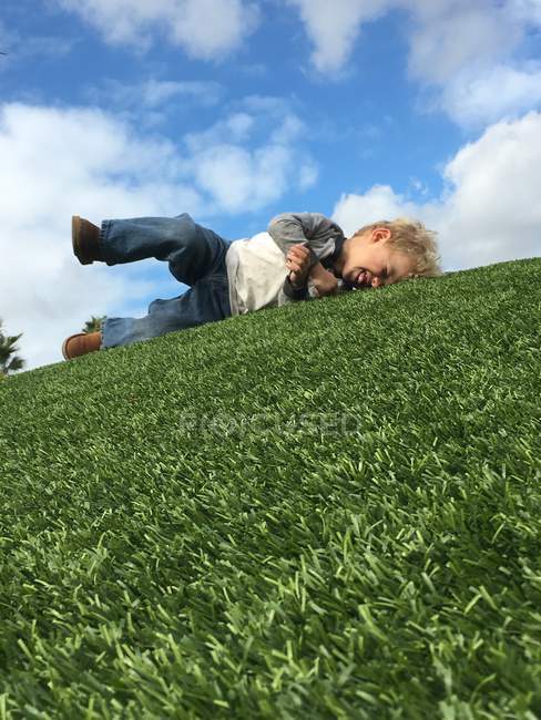 Хлопчик лежить на траві — стокове фото
