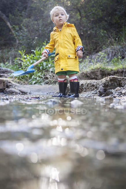 Niño jugando por arroyo - foto de stock