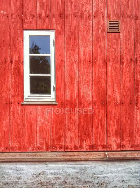 Exterior view of red wooden house with white window — Stock Photo