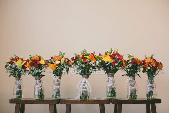 Schöne Braut und Brautjungfern Blumensträuße auf Holzhockern — Stockfoto