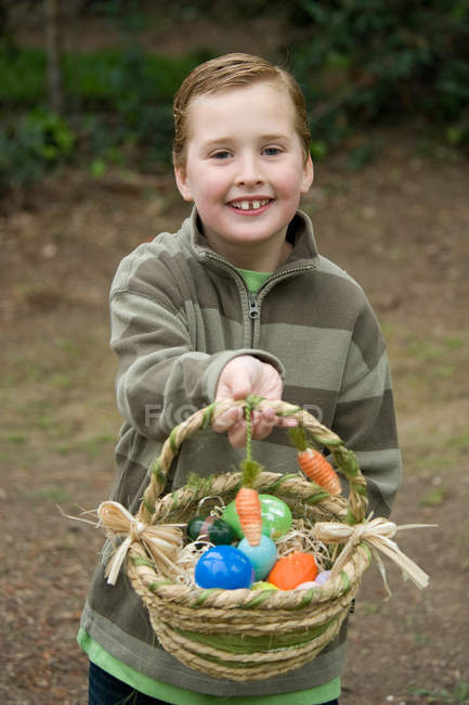Мальчик держит корзину с пасхальными яйцами — стоковое фото