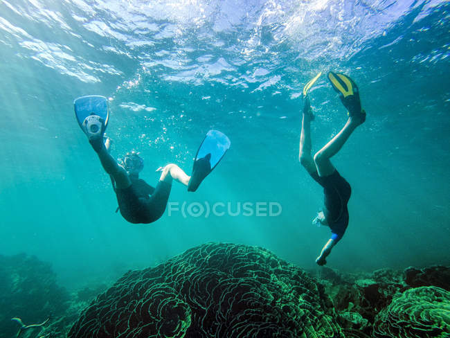 Boy and girl swimming together underwater — Stock Photo