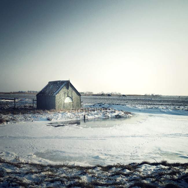 Vue panoramique de la cabane dans la neige sous le ciel gris — Photo de stock