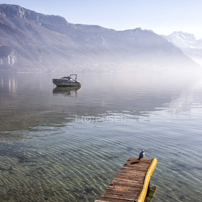 Scenic view of boat in foggy lake against mountains — Stock Photo