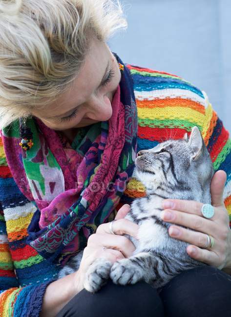 Happy woman sitting with cat on lap — Stock Photo