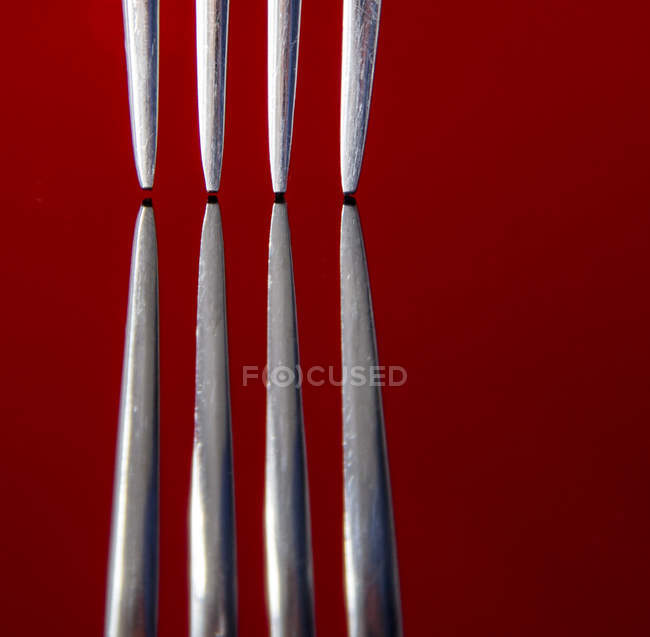 Image rapprochée de deux fourches sur fond rouge — Photo de stock