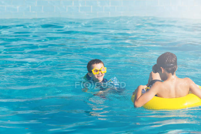 Due ragazzi caucasici che nuotano in acqua blu — Foto stock