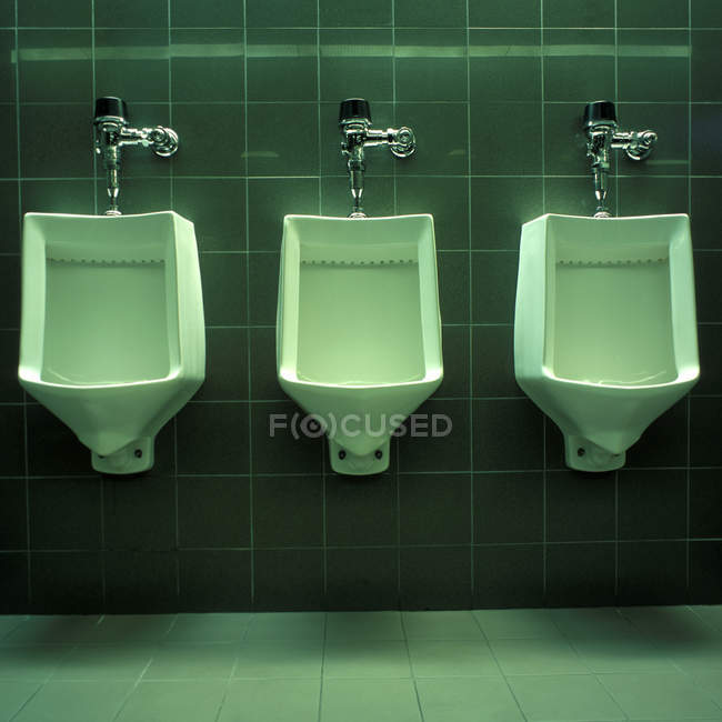 Ряд из трех писсуаров в общественном туалете — стоковое фото