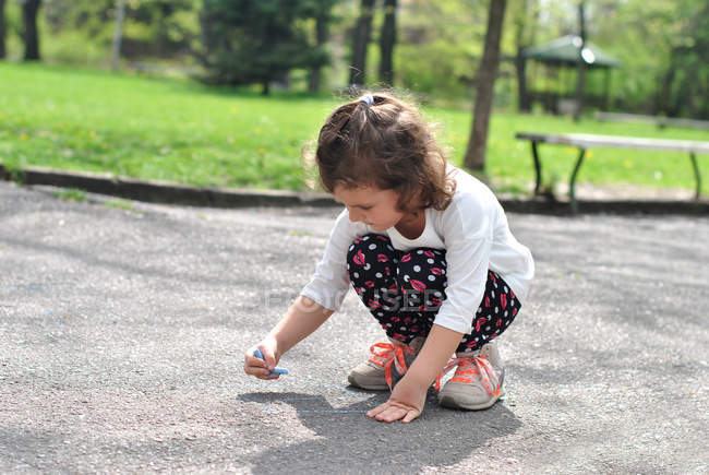 Mädchen zeichnet Hopscotch mit Kreide auf Straße — Stockfoto