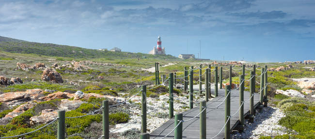 Vista panorámica del paseo marítimo de madera cerca del faro del cabo agulhas, Cabo Occidental, Sudáfrica - foto de stock