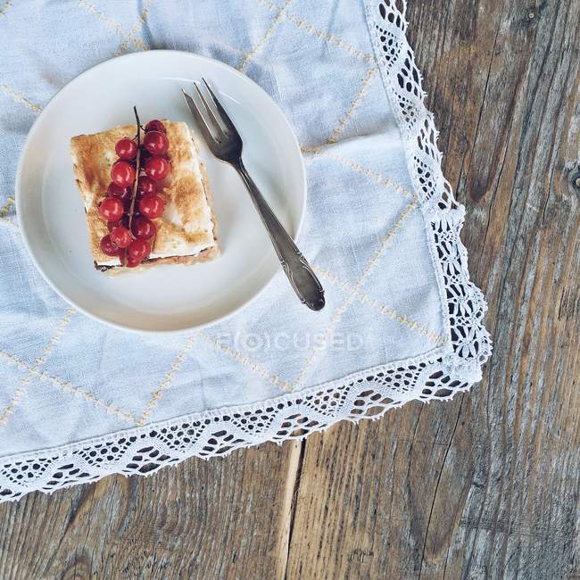 Slice of Rhubarb and meringue cake on plate on white napkin — Stock Photo