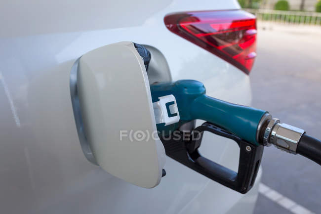Close-up of gas nozzle in fuel tank of a car — Stock Photo