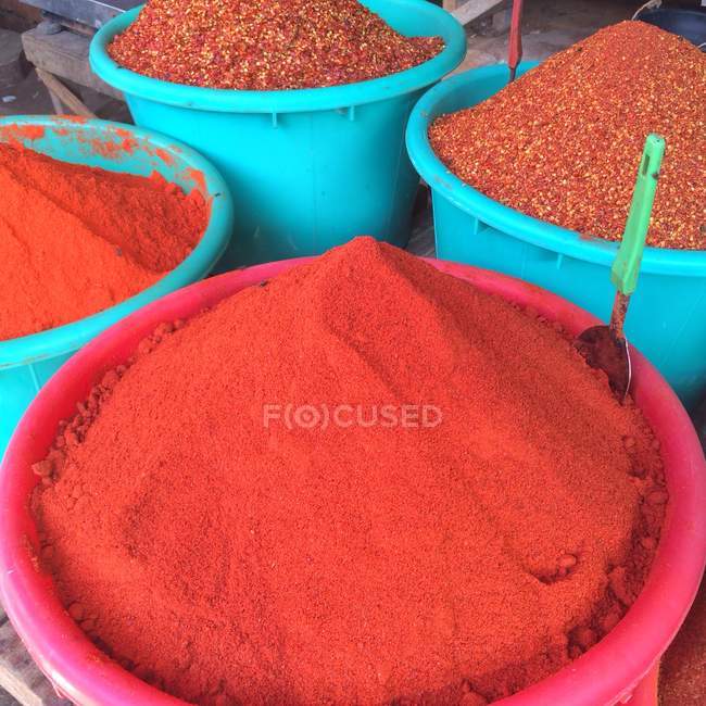 Blaue Eimer mit gemahlenem Chili auf dem Markt — Stockfoto