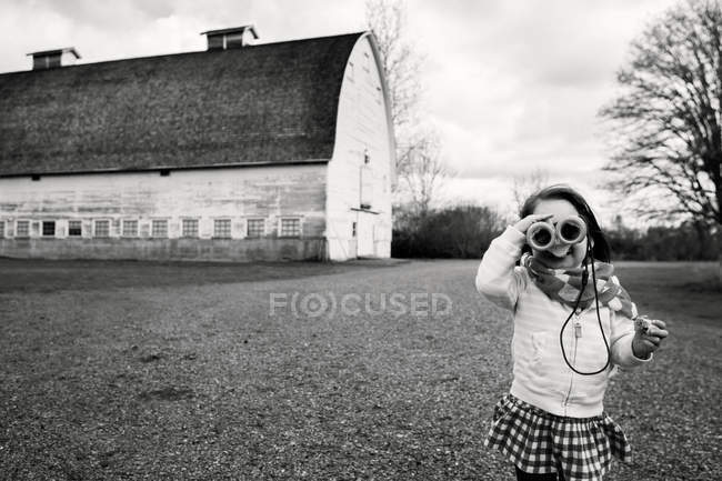 Очаровательная маленькая девочка смотрит в бинокль — стоковое фото