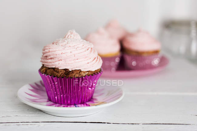 Four cupcakes on a table, blurred background — Stock Photo