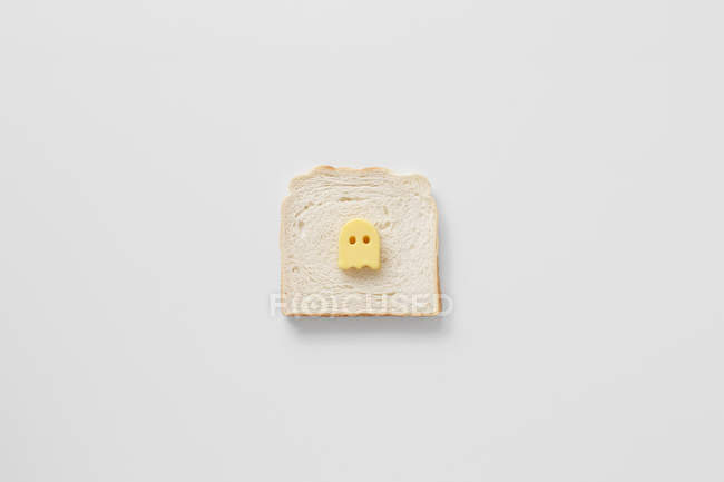 Konzeptioneller Buttergeist auf Brot vor weißem Hintergrund — Stockfoto