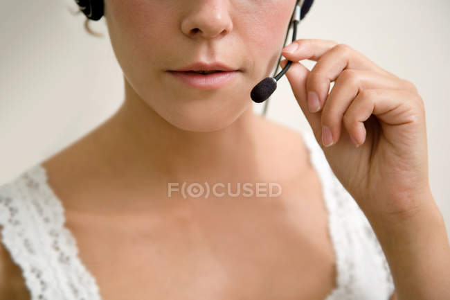 Close-up de mulher jovem usando fone de ouvido — Fotografia de Stock