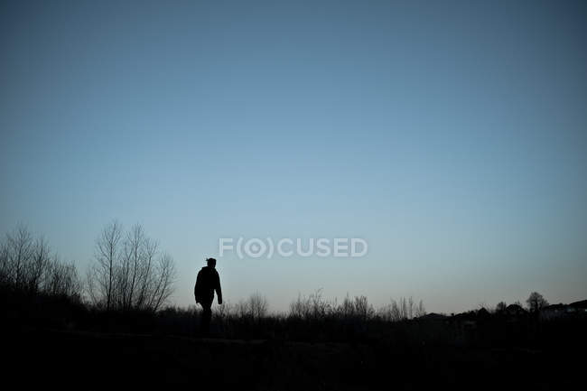 Vista panoramica della silhouette della donna che cammina al tramonto — Foto stock