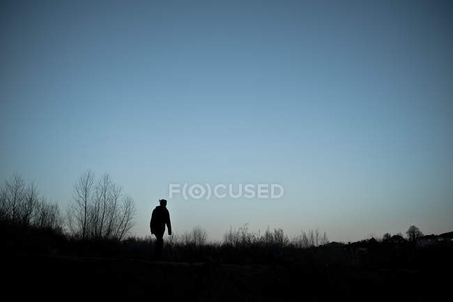 Vue panoramique de la silhouette de la femme marchant au crépuscule — Photo de stock