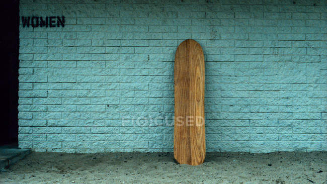 Wooden leaning against wall by women restroom — Stock Photo